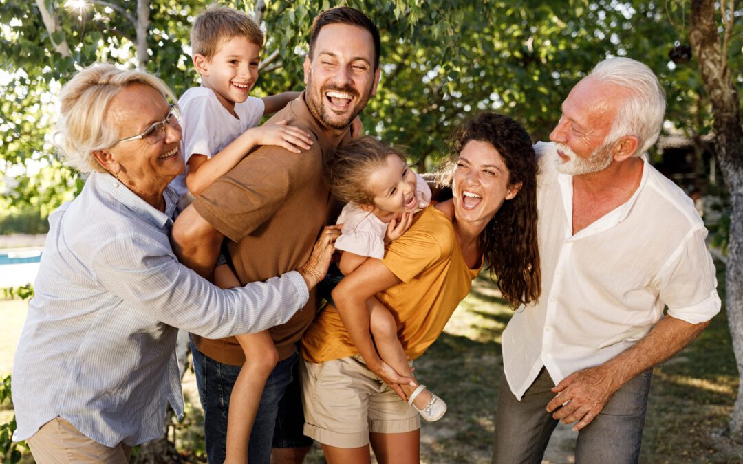 Candid photo of multi-generational family outside with young kids on their parents back representing the importance of using transfer on death (TOD) designations