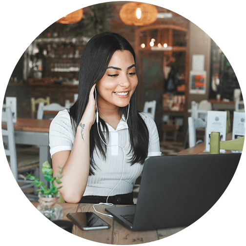 Woman business owner in cafe on laptop looking over her financial plan