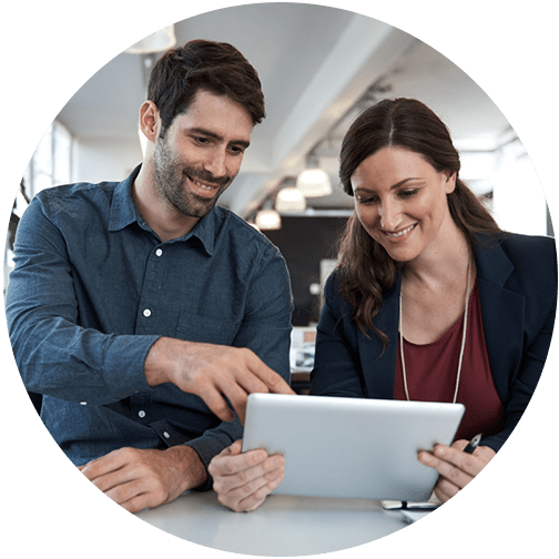 Two professionals mid-career looking at a tablet and discussing a client project