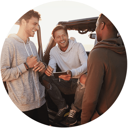 Three male friends sitting at jeep and talking about their investments