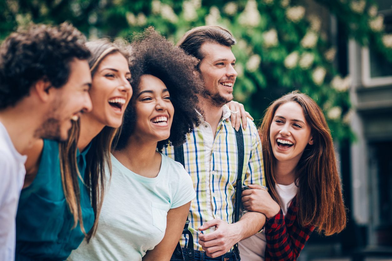 Group of five adults laughing with each other all with different investment personalities